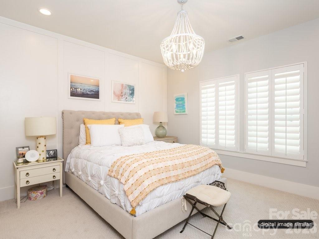 134 Willow Vw Loop, Unit 1 Davidson, NC 28036 - Photo 31 of 42 a bedroom with a large bed and a chandelier