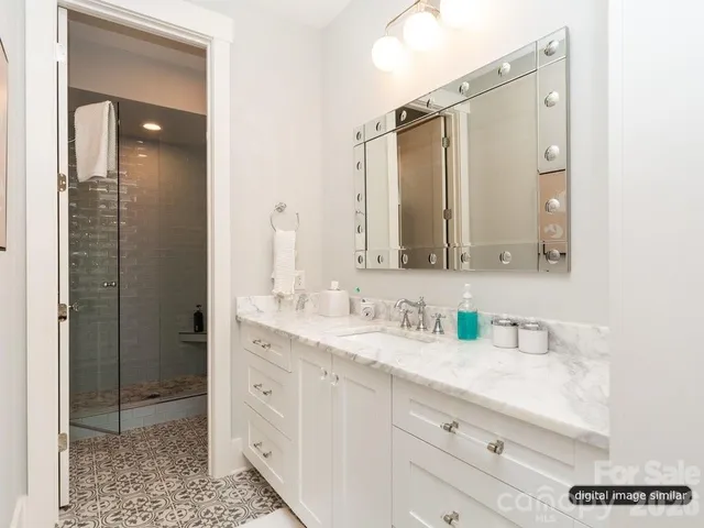 a bathroom with a double vanity sink mirror and shower