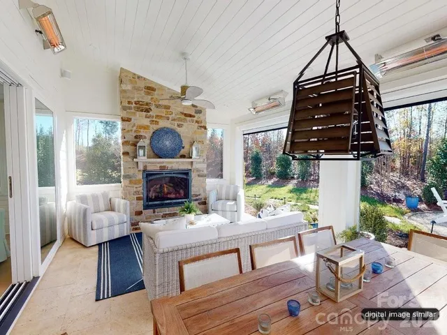 a living room with furniture a fireplace and a chandelier