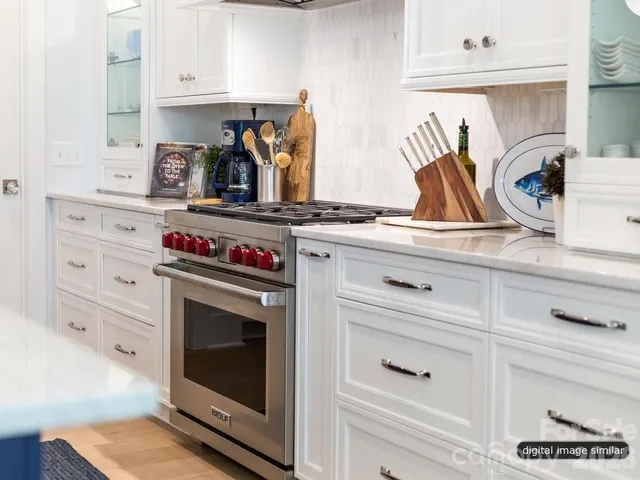 a kitchen with white cabinets and appliances