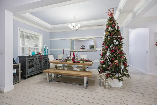 a living room with furniture a chandelier and a potted plant