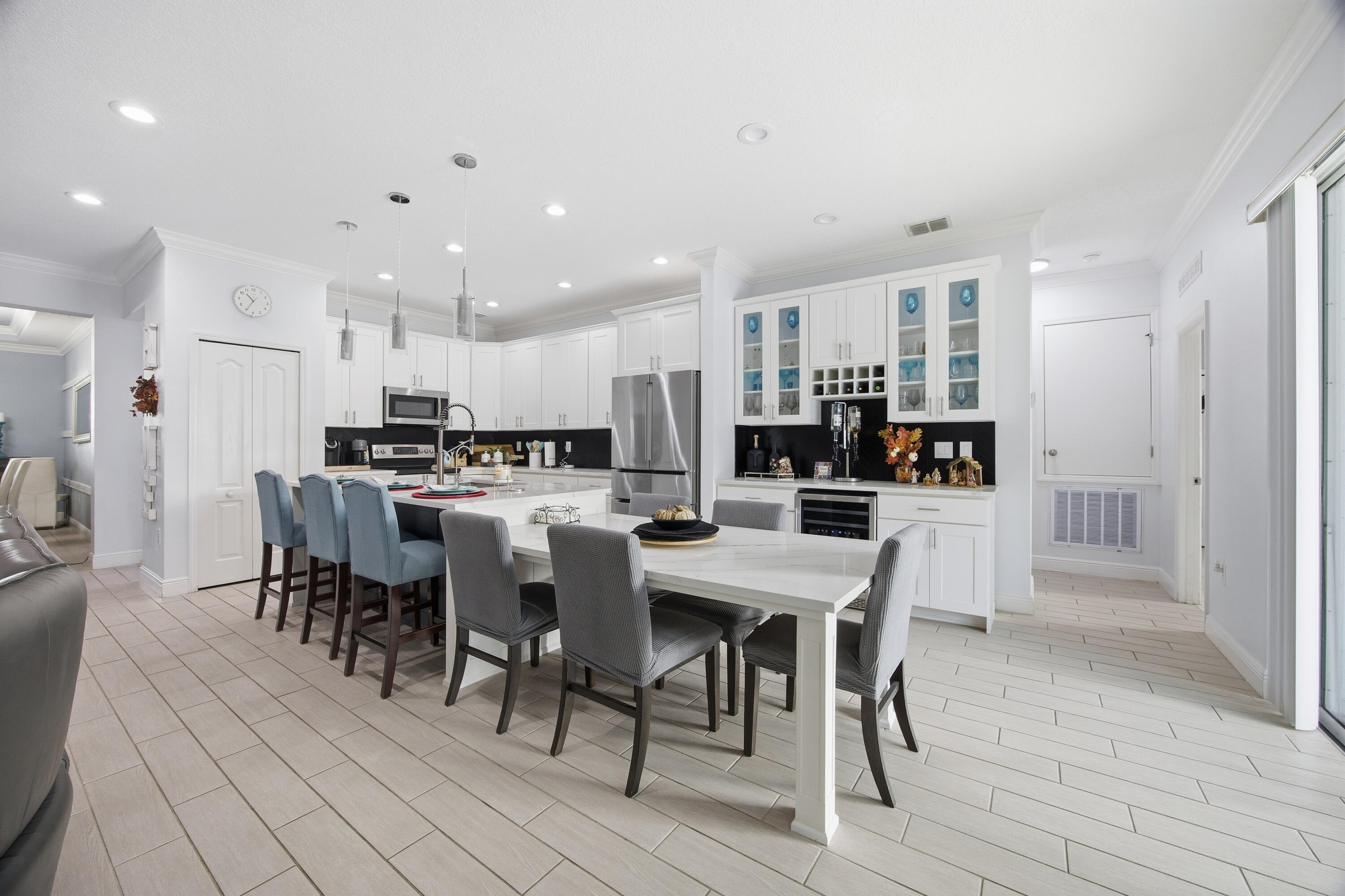 2758 Southwest Onaway Avenue Port St. Lucie, FL 34987 - Photo 16 of 49 a kitchen with stainless steel appliances kitchen island granite countertop a dining table chairs and stove top oven with wooden floor