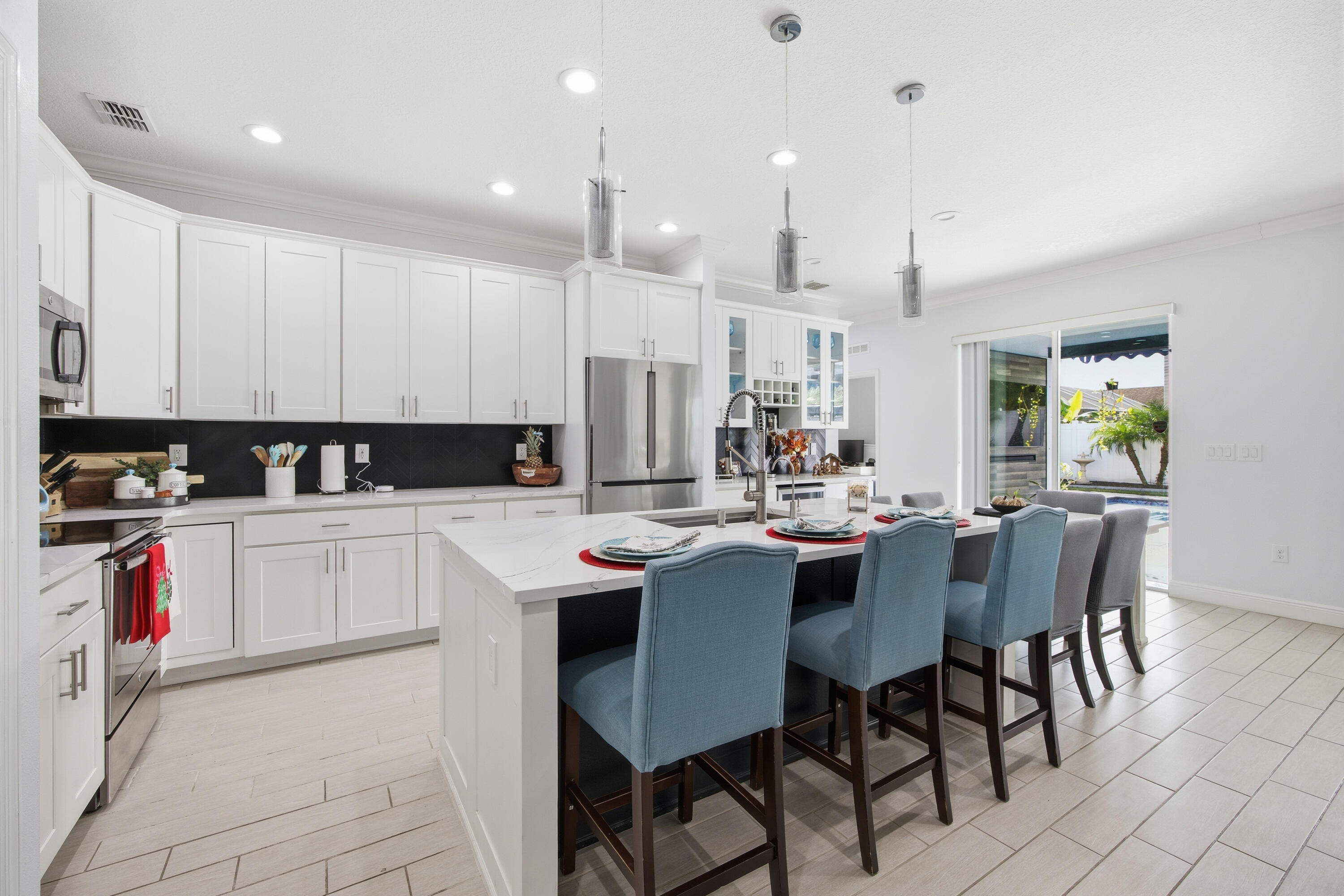2758 Southwest Onaway Avenue Port St. Lucie, FL 34987 - Photo 17 of 49 a kitchen with a sink dining table and chairs