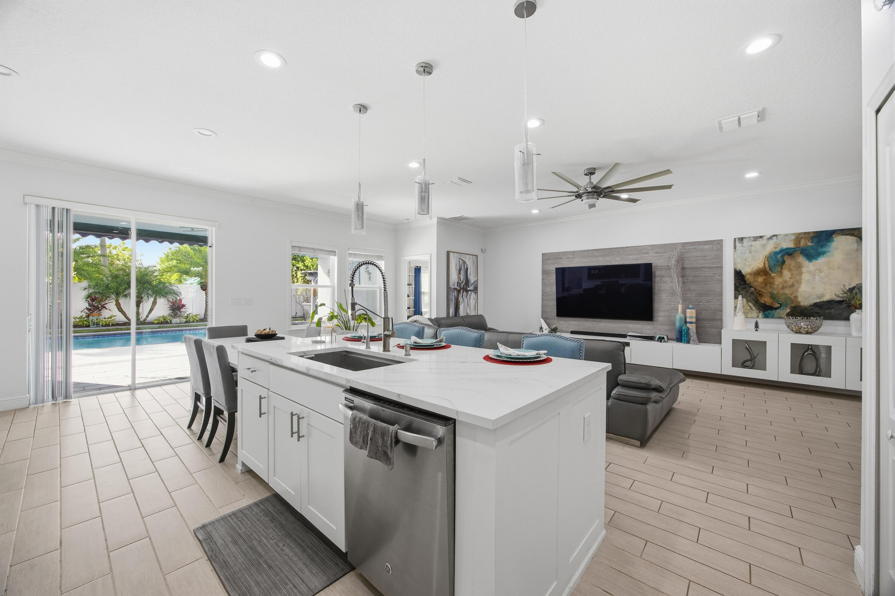 2758 Southwest Onaway Avenue Port St. Lucie, FL 34987 - Photo 19 of 49 a large white kitchen with a large island in the center and living room