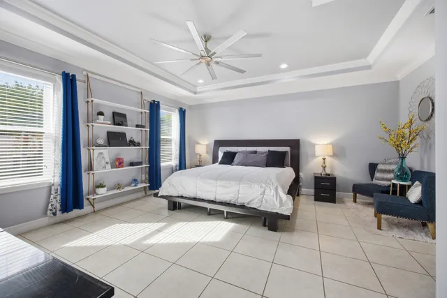 a bedroom with a large bed and a chandelier fan