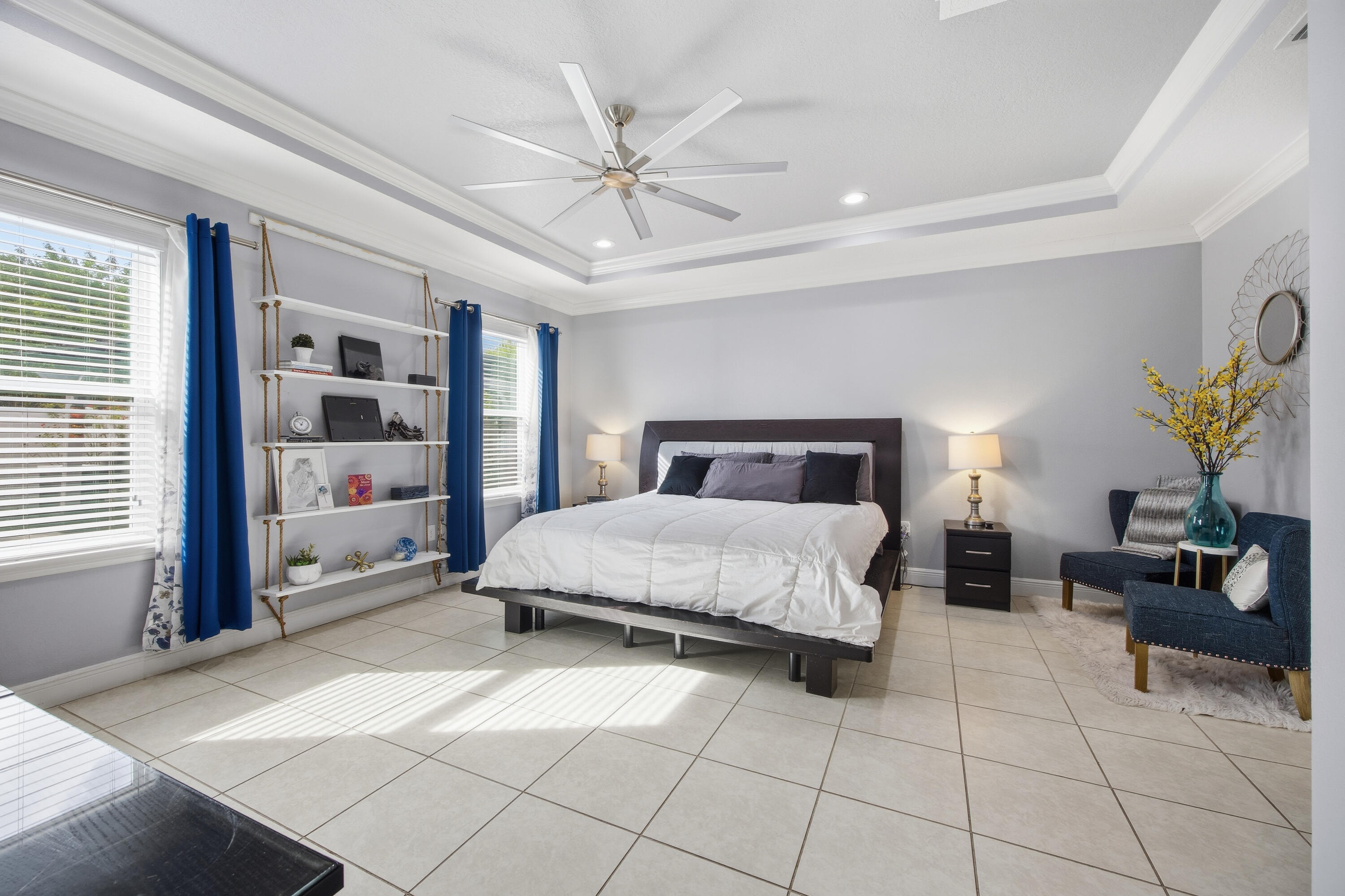 2758 Southwest Onaway Avenue Port St. Lucie, FL 34987 - Photo 20 of 49 a bedroom with a large bed and a chandelier fan