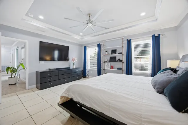 a bedroom with a bed a flat screen tv and a dresser