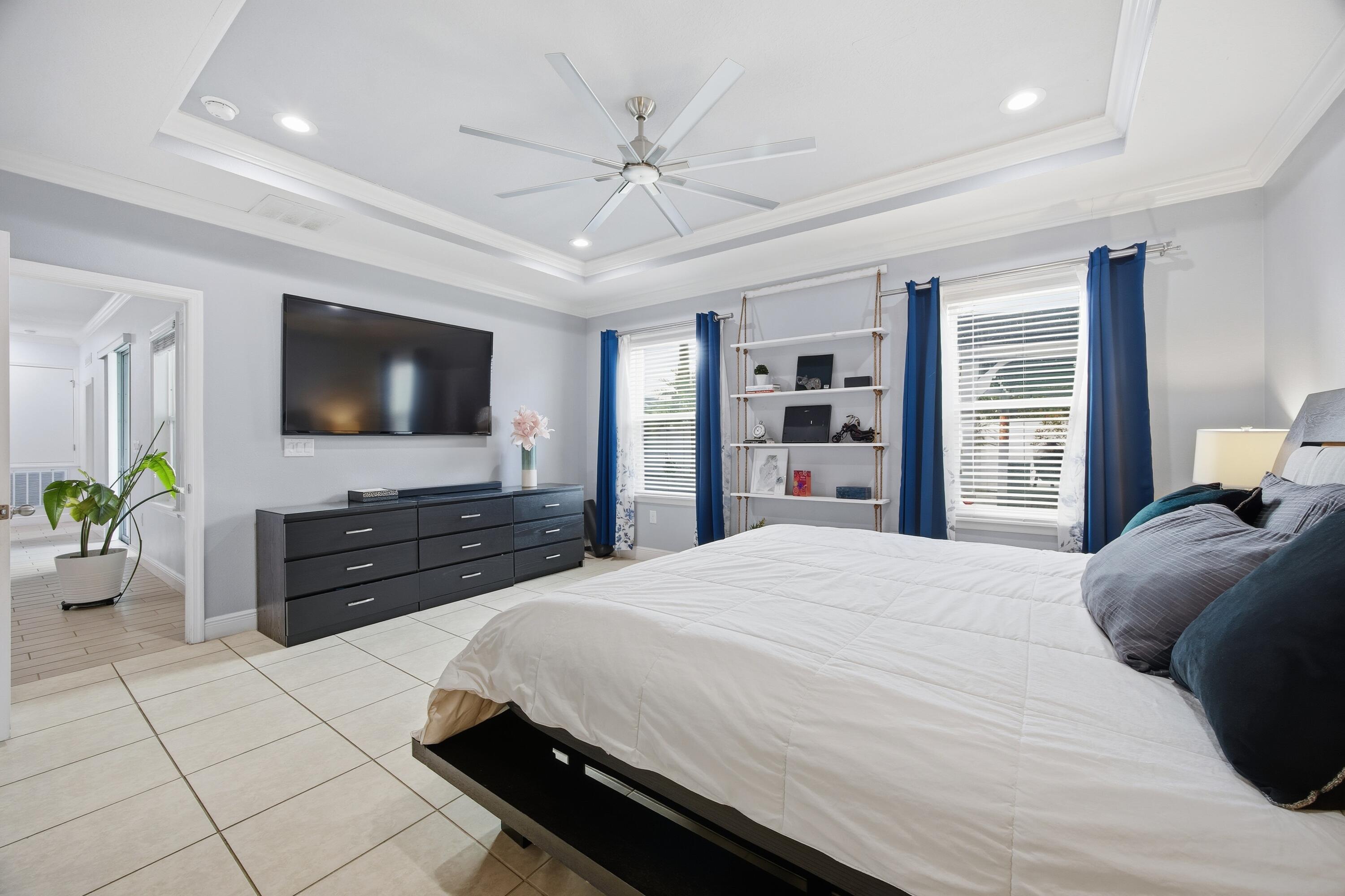 2758 Southwest Onaway Avenue Port St. Lucie, FL 34987 - Photo 21 of 49 a bedroom with a bed a flat screen tv and a dresser