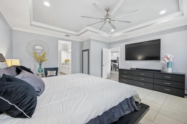 a bedroom with a bed and a flat tv screen on dresser