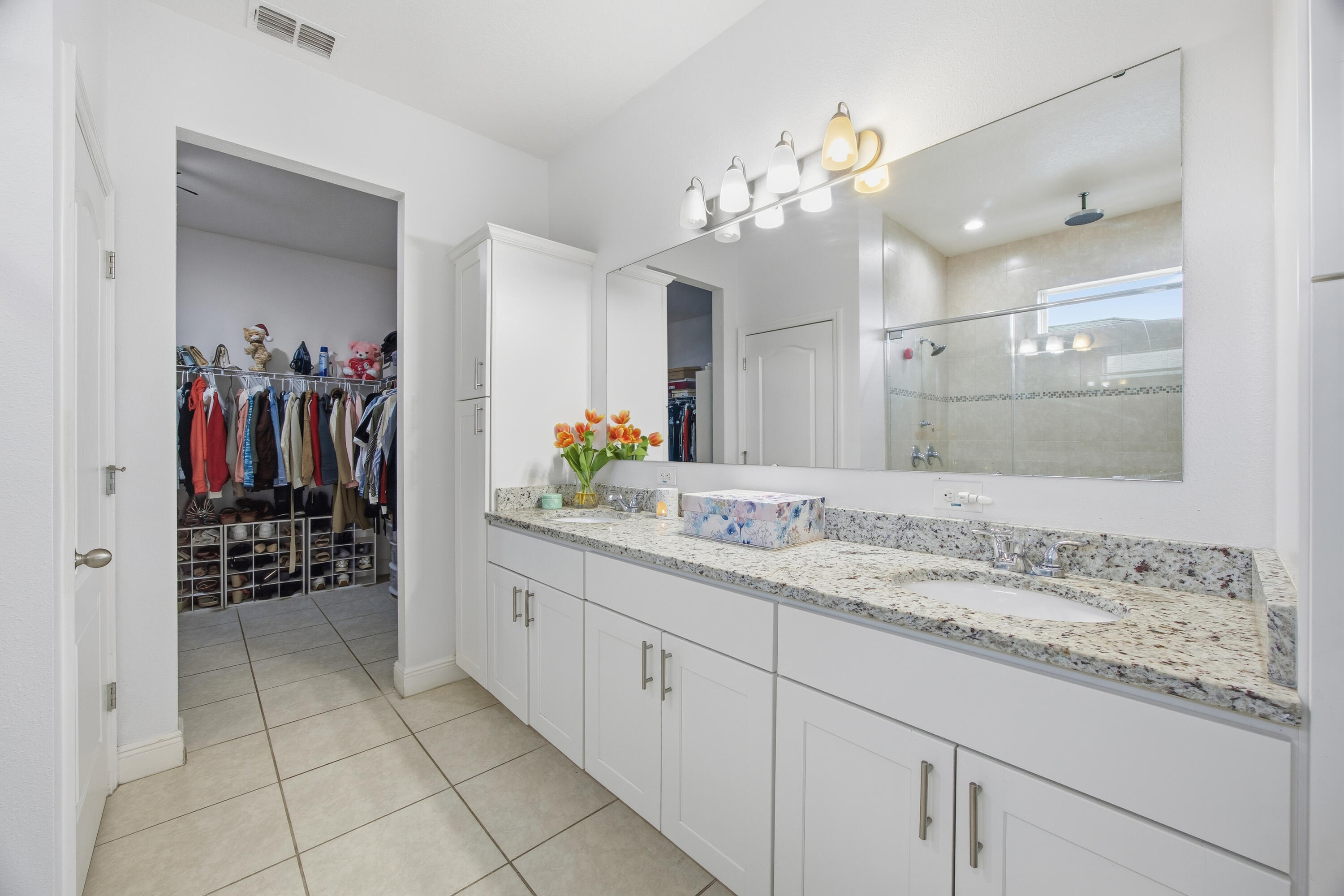 2758 Southwest Onaway Avenue Port St. Lucie, FL 34987 - Photo 23 of 49 a bathroom with a granite countertop sink a mirror and a shower