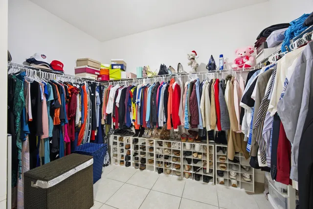 a view of walk in closet with clothes and shoes