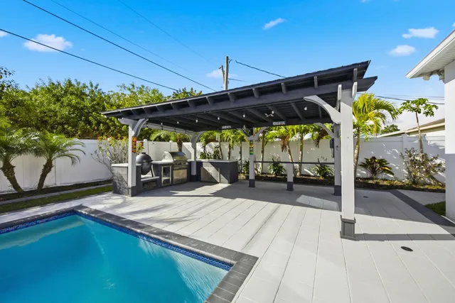 a view of a patio with table and chairs under an umbrella