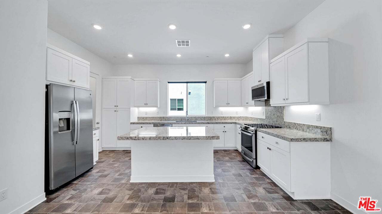 27009 Hummingbird Lane Valencia, CA 91381 - Photo 14 of 35 a kitchen with stainless steel appliances granite countertop a refrigerator a stove and a sink