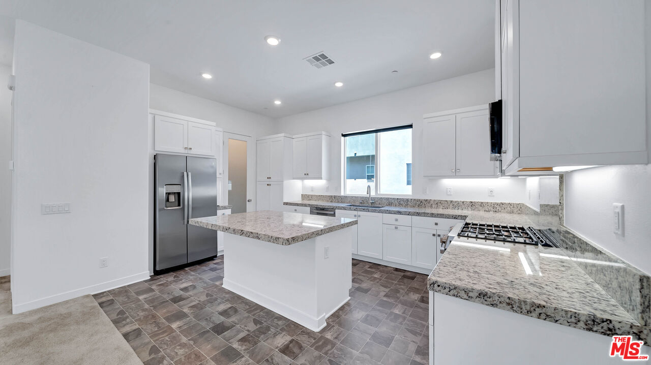 27009 Hummingbird Lane Valencia, CA 91381 - Photo 15 of 35 a kitchen with a sink stove and refrigerator