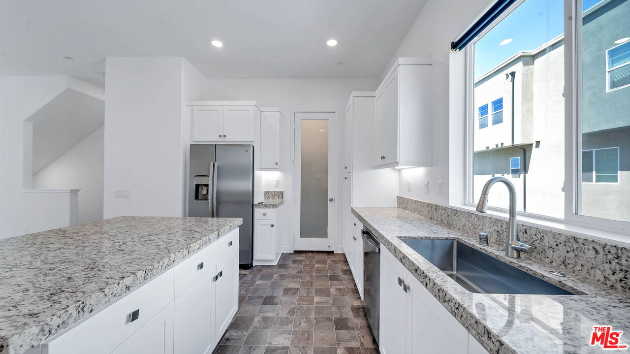 27009 Hummingbird Lane Valencia, CA 91381 - Photo 18 of 35 a kitchen with granite countertop a sink stainless steel appliances and counter space