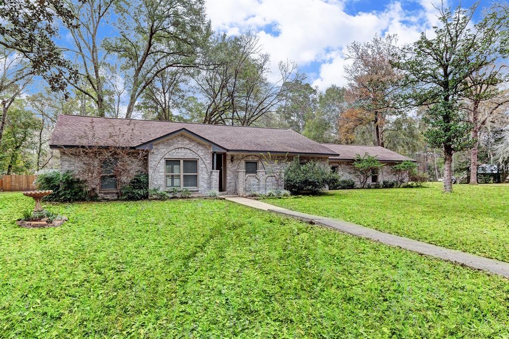 a aerial view of a house next to a big yard and large trees