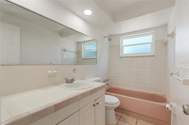 a bathroom with a sink a toilet a tub and shower