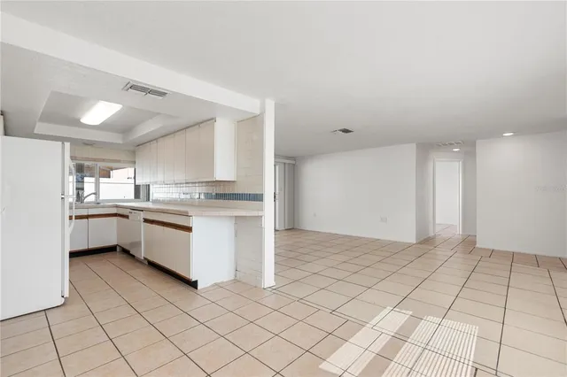 a large white kitchen with a sink and cabinets