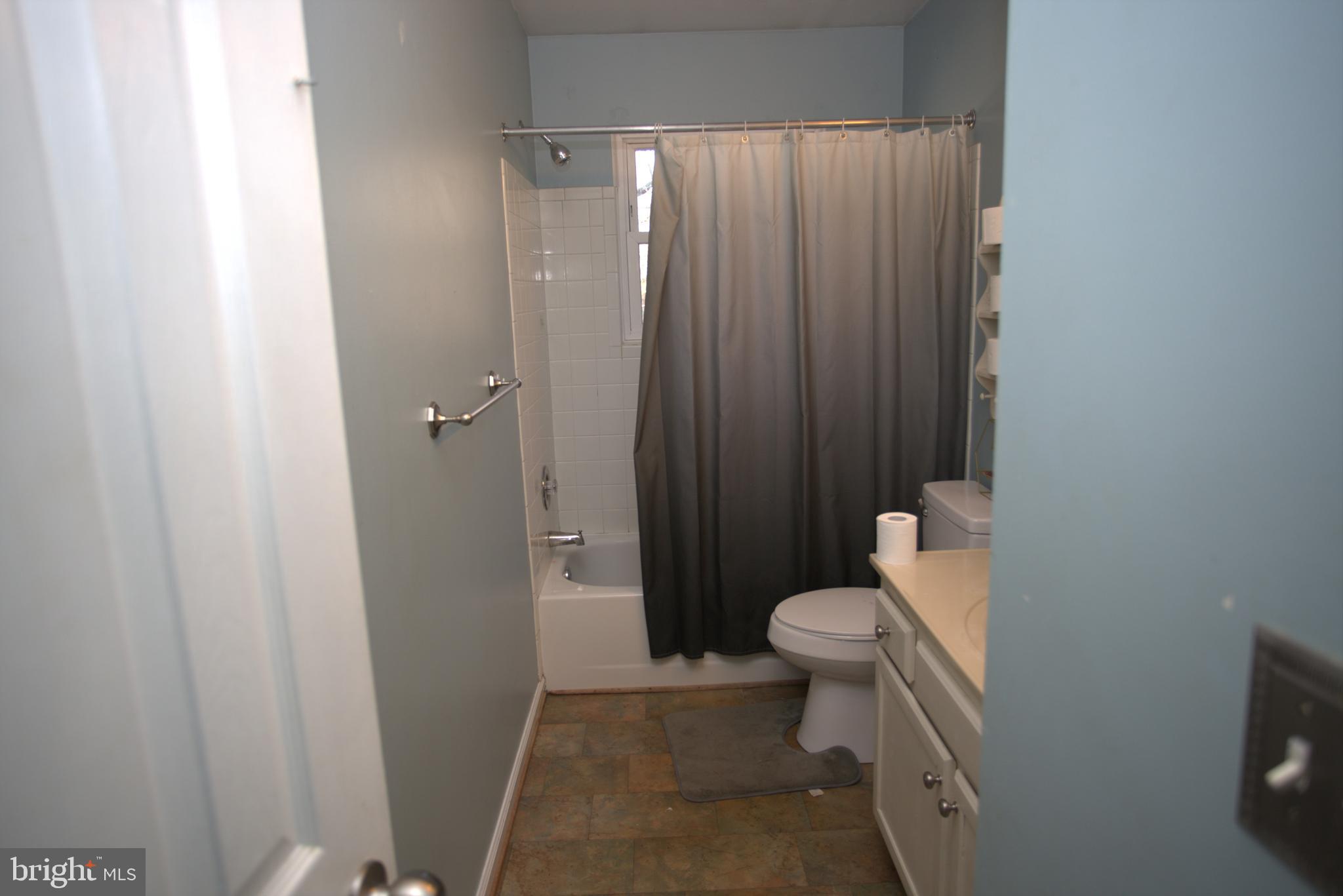 542 Chisholm Trail Lusby, MD 20657 - Photo 13 of 29 a bathroom with a sink a toilet and shower curtain