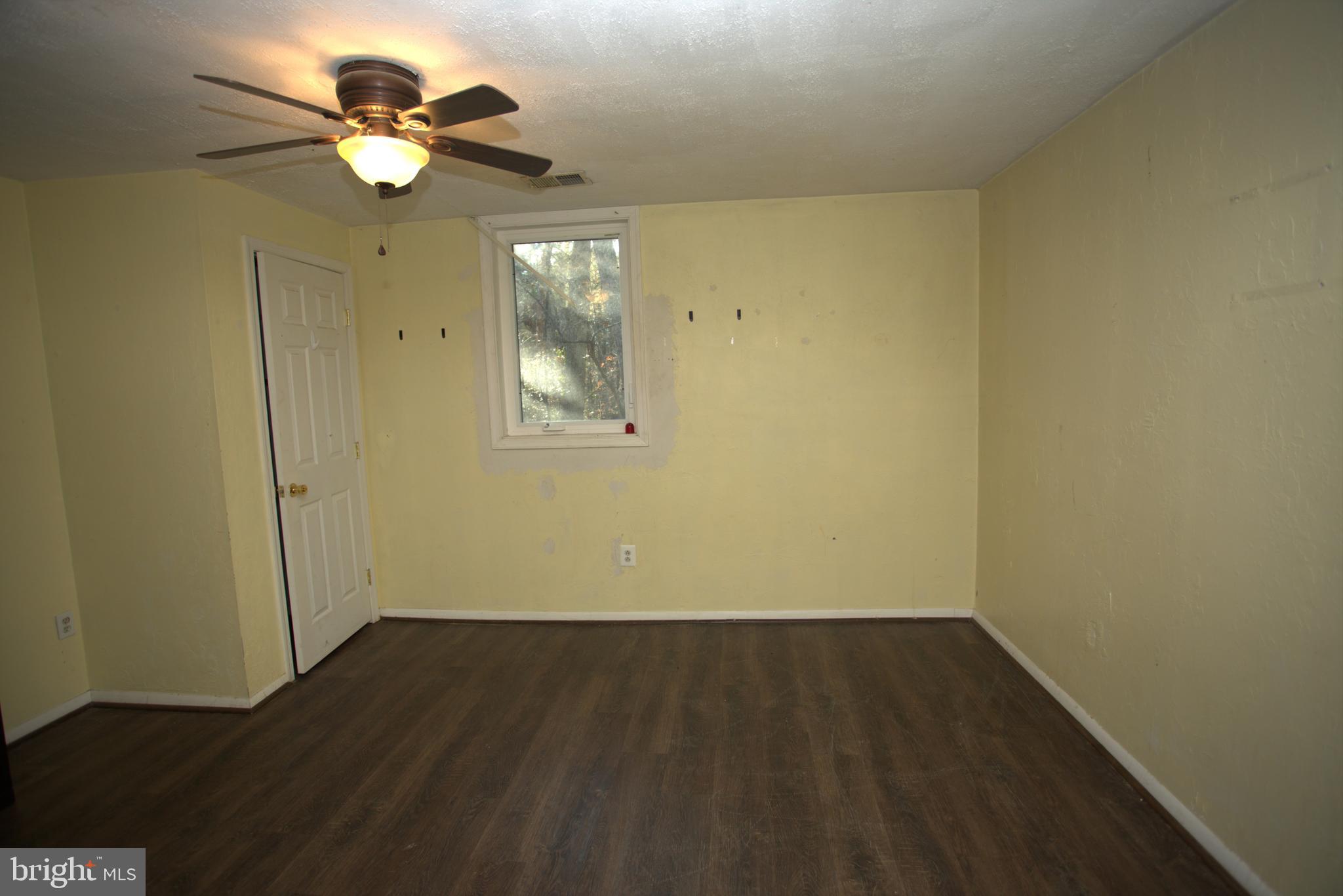 542 Chisholm Trail Lusby, MD 20657 - Photo 19 of 29 an empty room with wooden floor and windows