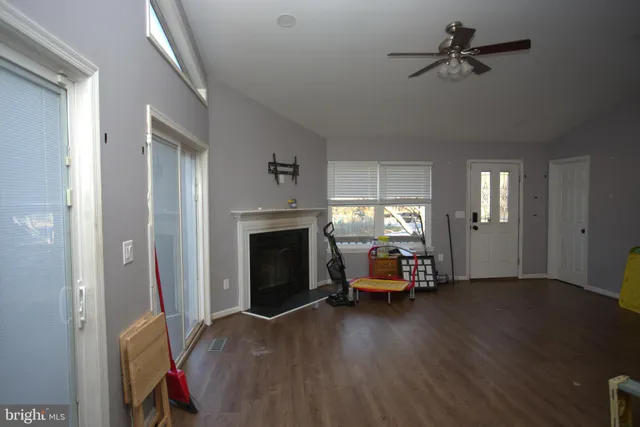a view of a livingroom with furniture a fireplace window and wooden floor