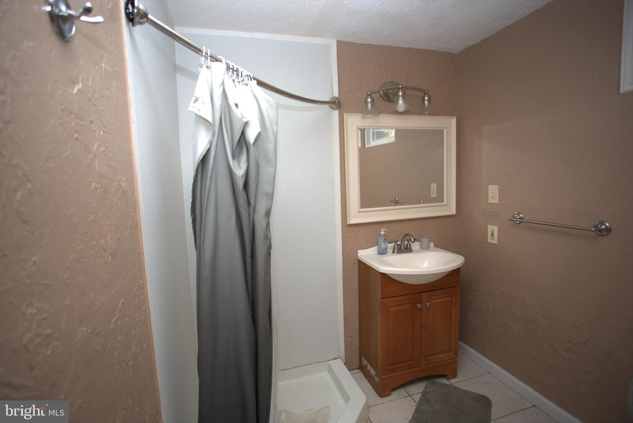 542 Chisholm Trail Lusby, MD 20657 - Photo 21 of 29 a bathroom with a sink and mirror with toilet
