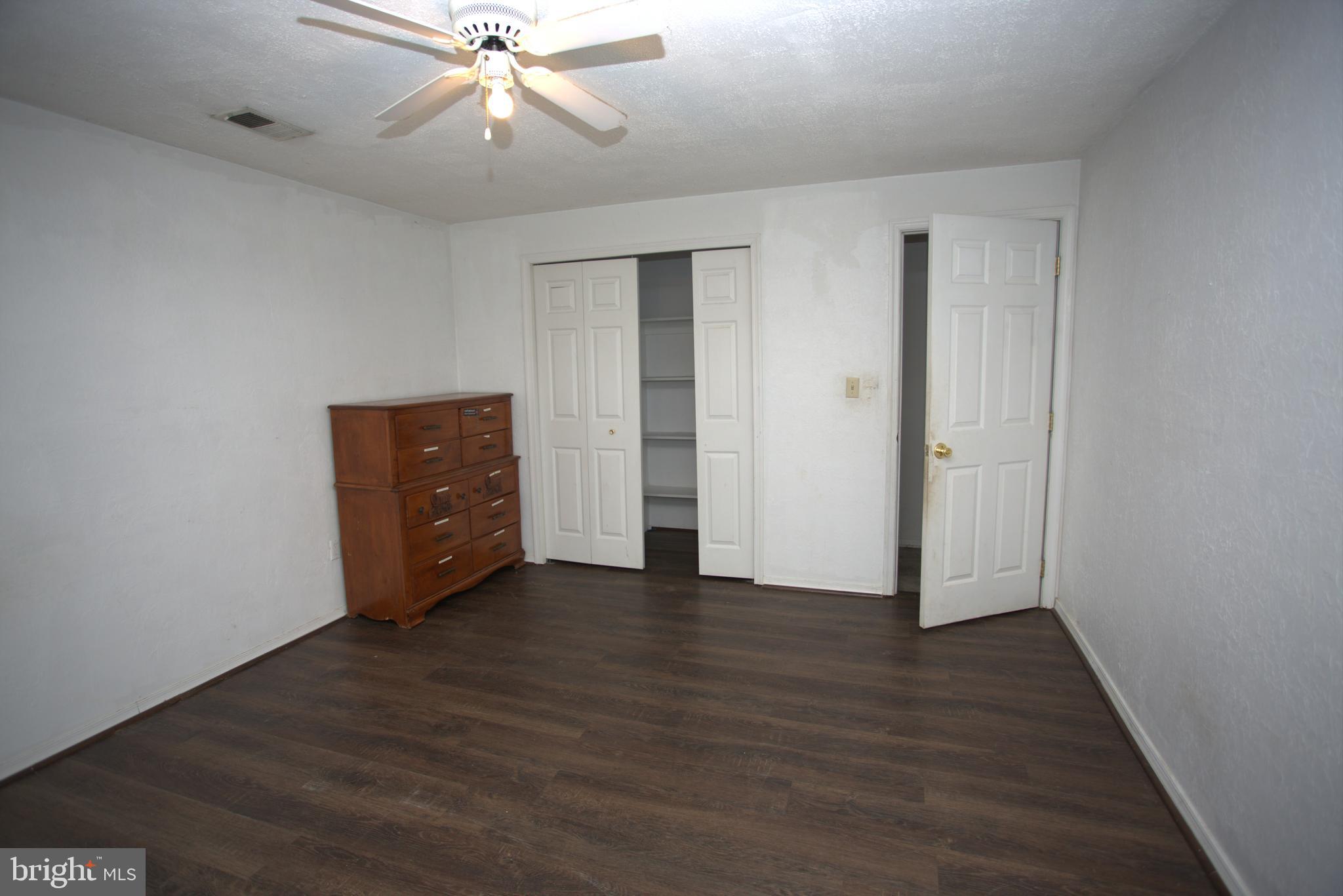 542 Chisholm Trail Lusby, MD 20657 - Photo 26 of 29 an empty room with wooden floor ceiling fan and windows