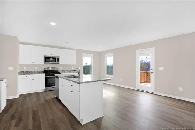 a kitchen with granite countertop white cabinets and white appliances