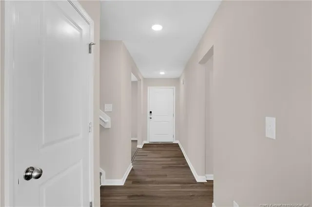 a view of a hallway with wooden floor and staircase