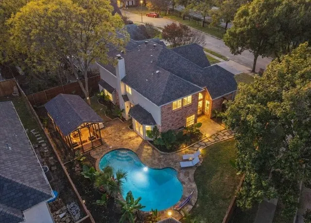 an aerial view of a house with a yard and lake view