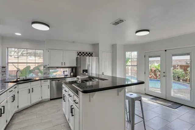 a kitchen with granite countertop a sink stove and cabinets