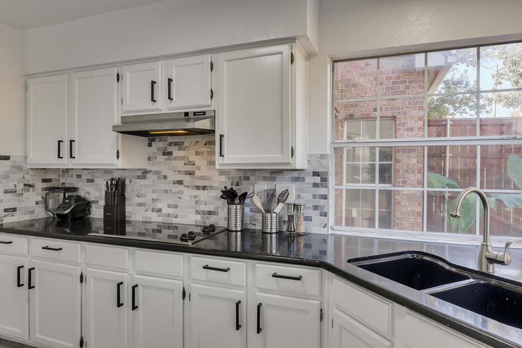 4402 Goodwin Drive Grand Prairie, TX 75052 - Photo 18 of 39 a kitchen with white cabinets a sink and a window