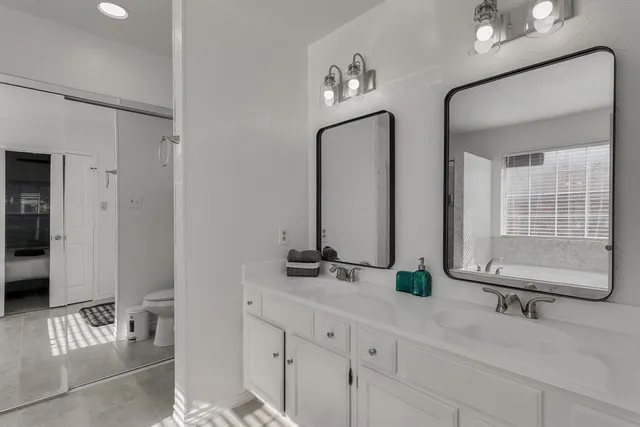 a bathroom with double vanity sinks a mirror and a shower