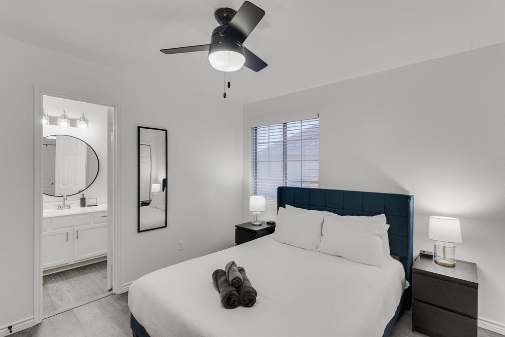 4402 Goodwin Drive Grand Prairie, TX 75052 - Photo 23 of 39 a bedroom with a bed and a chandelier