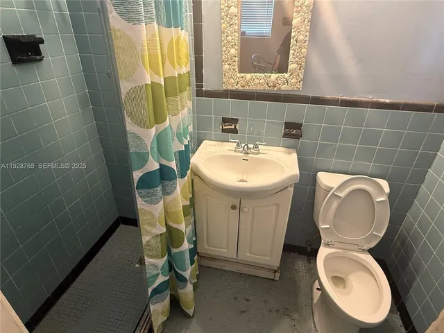 a bathroom with a toilet a sink and a mirror