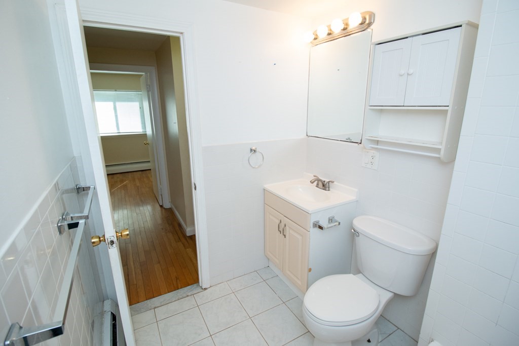 58 Bishop Drive, Unit 58 Framingham, MA 01702 - Photo 12 of 13 a white toilet sitting next to a bathroom sink