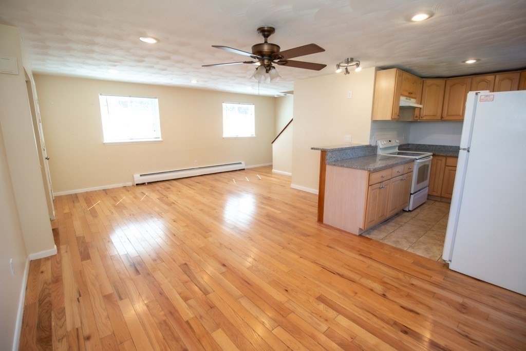 58 Bishop Drive, Unit 58 Framingham, MA 01702 - Photo 4 of 13 a kitchen with granite countertop a stove a sink and a refrigerator