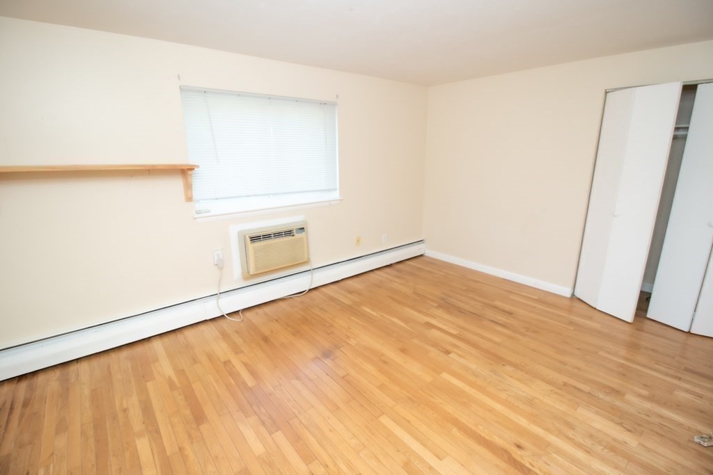 58 Bishop Drive, Unit 58 Framingham, MA 01702 - Photo 10 of 13 a view of empty room with wooden floor and cabinet