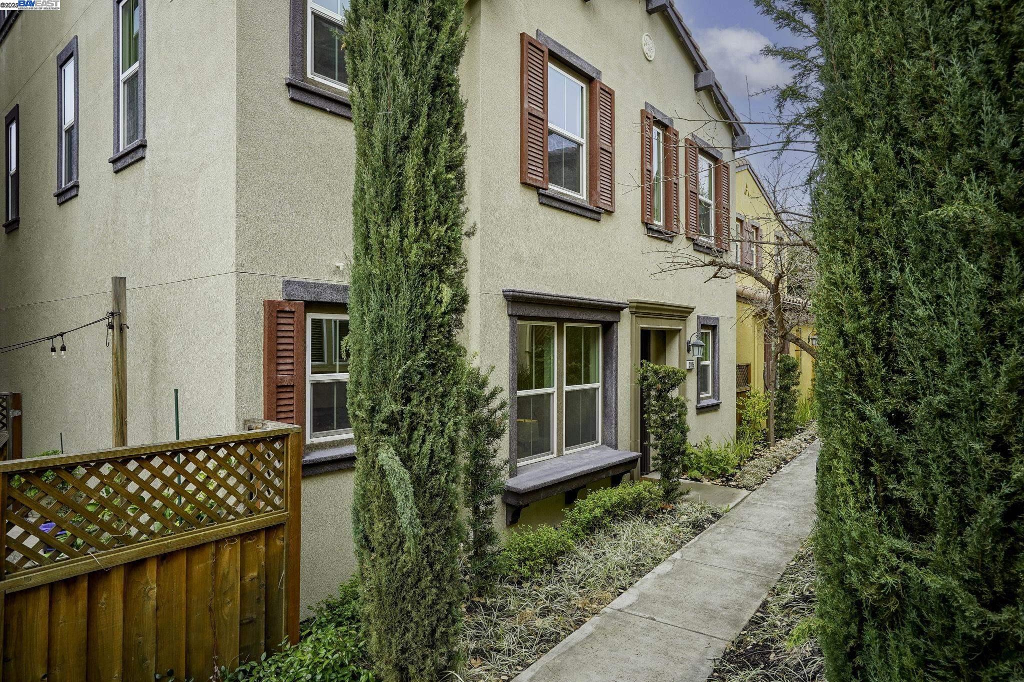 a view of a brick house with plants and large windows