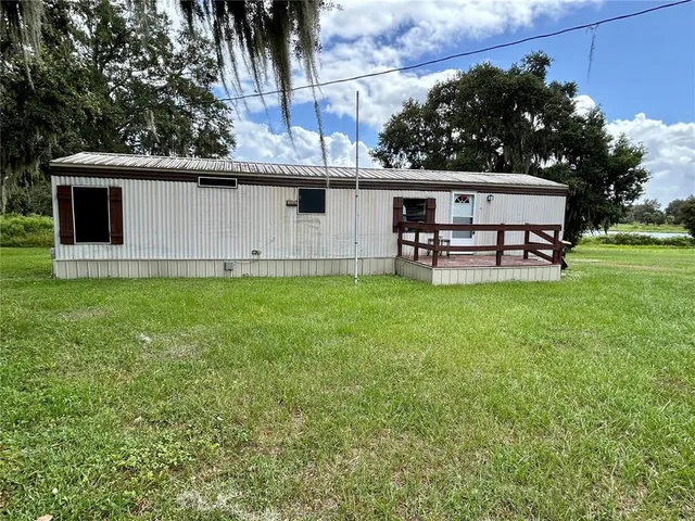 a view of a house with a backyard and a tree