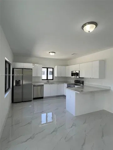 a kitchen with kitchen island a sink stainless steel appliances and cabinets