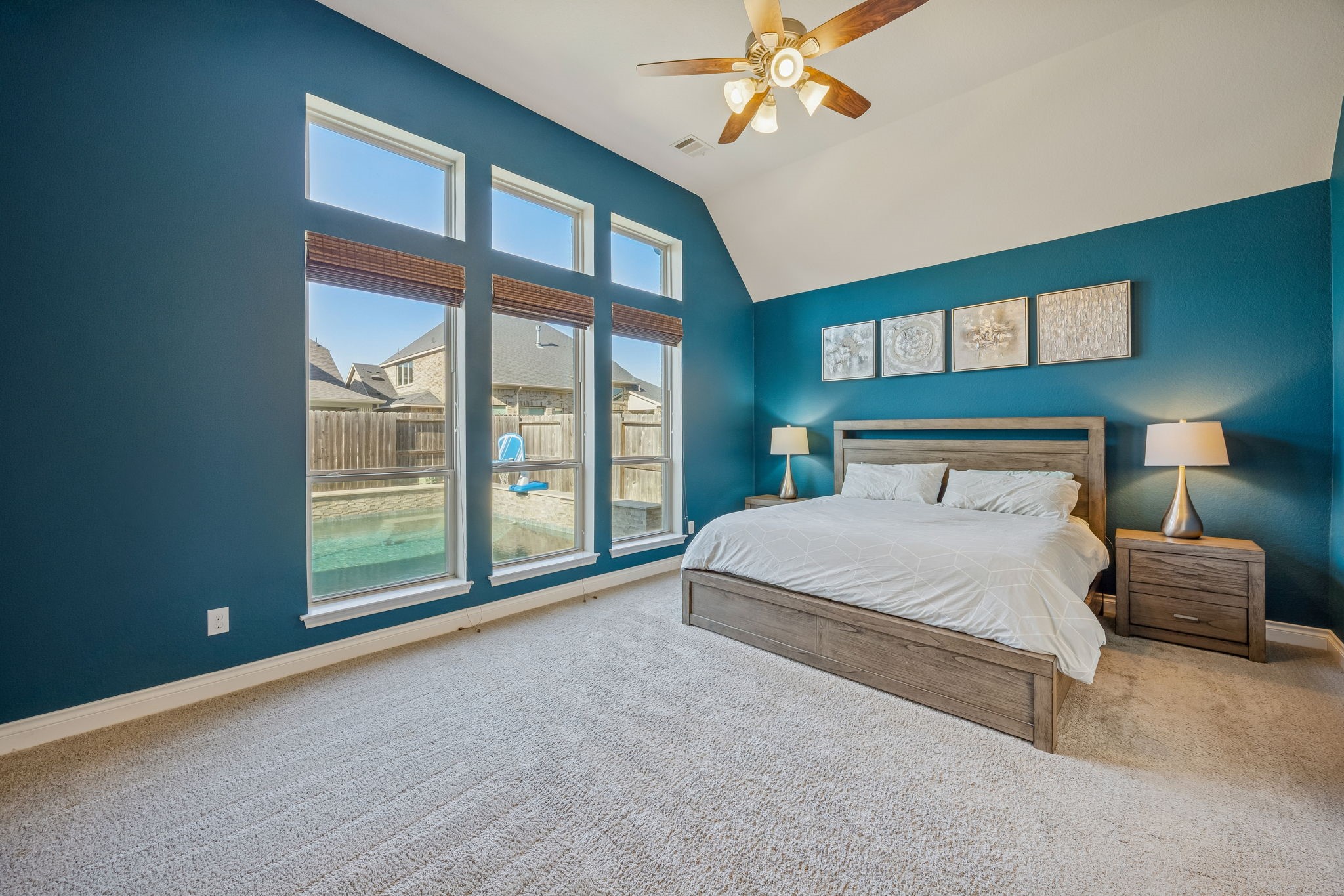 28706 Casen Ranch Lane Fulshear, TX 77441 - Photo 14 of 31 The spacious first-floor Primary Suite is a tranquil sanctuary featuring soaring vaulted ceilings and large windows that offer a private view of the sparkling pool and backyard oasis.
