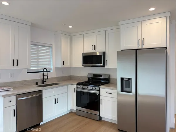 a kitchen with a sink appliances and cabinets