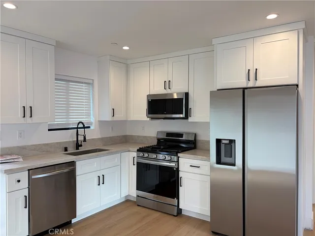 a kitchen with a sink appliances and cabinets