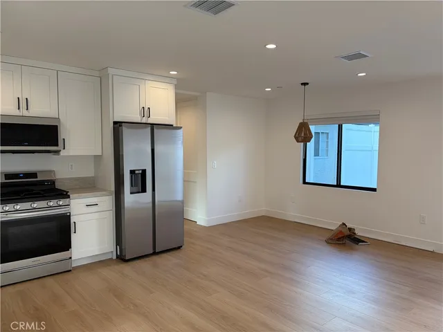 a view of kitchen with stainless steel appliances granite countertop a stove a refrigerator and a microwave