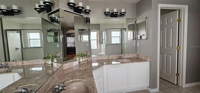 a spacious bathroom with a granite countertop sink mirror and shower
