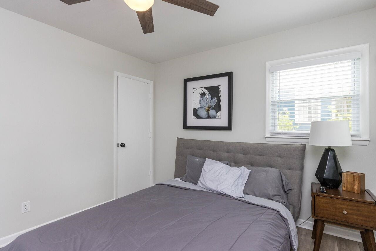 1415 Berkeley Street Durham, NC 27705 - Photo 17 of 24 a bedroom with a bed and a lamp on dresser