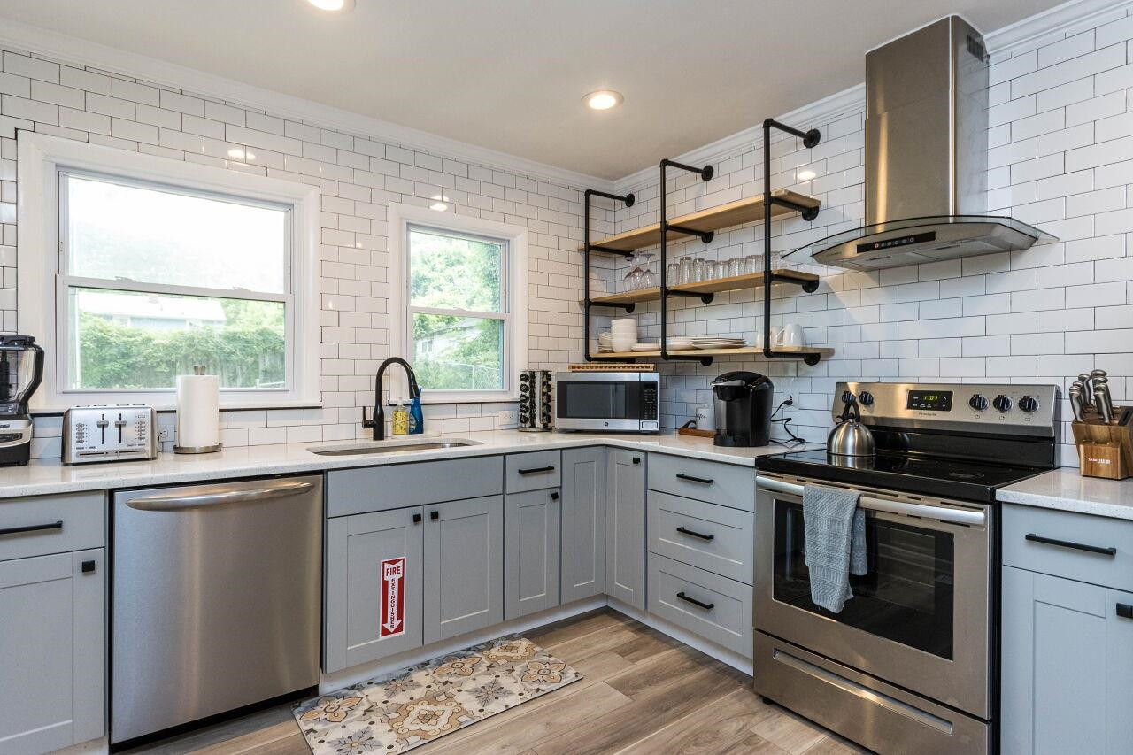 1415 Berkeley Street Durham, NC 27705 - Photo 9 of 24 a kitchen with stainless steel appliances a stove sink and cabinets