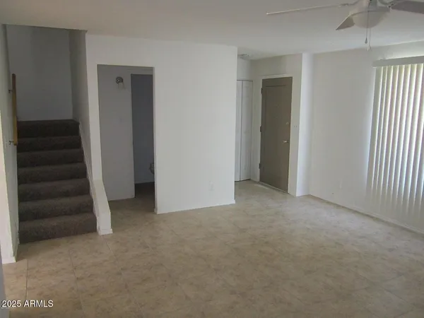 an empty room with a hallway and stairs