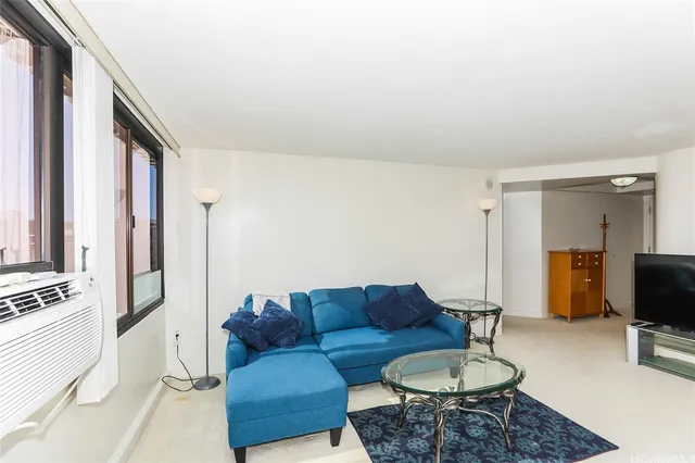 a living room with furniture a flat screen tv and a window